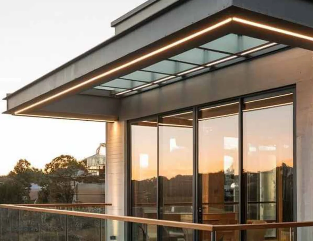 Glass balcony railing on a modern home at dusk